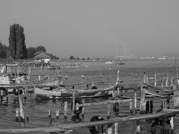 Boats moored at harbor against sky