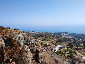 Panoramic view of buildings and mountains against clear blue sky