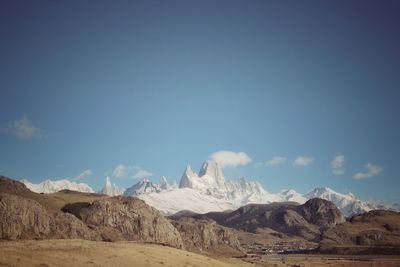 Scenic view of snowcapped mountains against blue sky