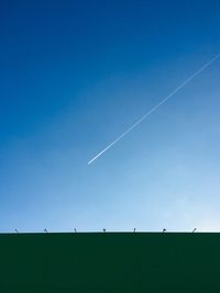 Low angle view of vapor trail against blue sky