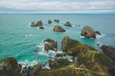 Scenic view of rocks in sea against sky