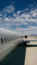 Close-up of airplane on airport against sky