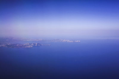 Aerial view of sea against clear blue sky