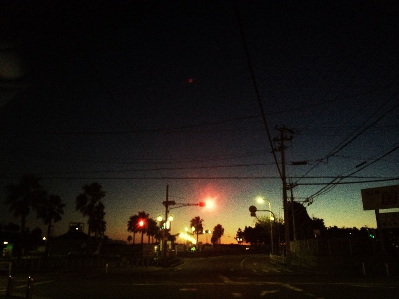 illuminated, sky, street light, silhouette, tree, power line, lighting equipment, low angle view, sunset, street, dusk, electricity, electricity pylon, building exterior, outdoors, cable, night, built structure, city, car