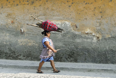 Full length of woman sitting on wall