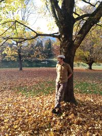 Full length of man standing by tree in park during autumn