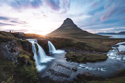 Scenic view of waterfall against sky during sunset