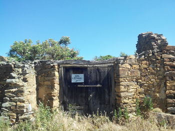 Abandoned building against clear blue sky