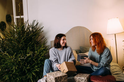 Young woman sitting on sofa at home