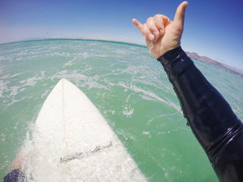 Midsection of person by sea against sky