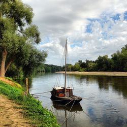 Boat sailing on river against sky