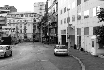 Cars on road by buildings in city