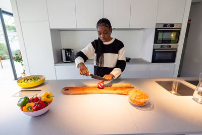 Portrait of woman holding food on table