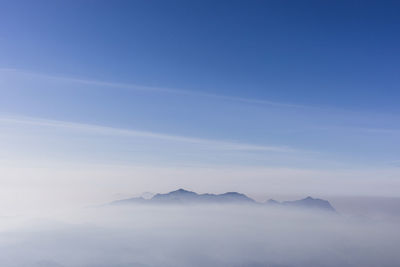 Scenic view of mountains against blue sky