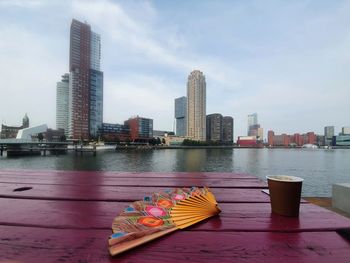 Buildings by river against sky in city