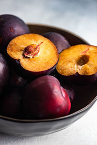Plums in bowl on table