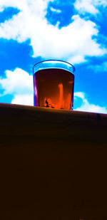 Low angle view of beer glass against orange sky