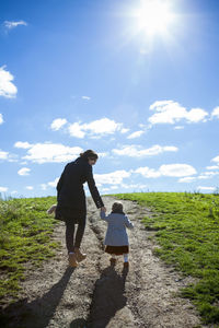 Mother and daughter hand in hand walking up pathway in detroit mi