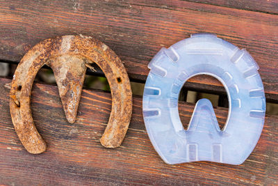 Old rusty iron horseshoe and modern plastic horseshoe made of composite material