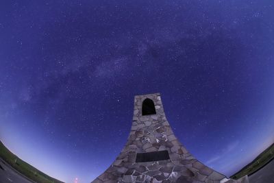 Low angle view of cross against sky at night