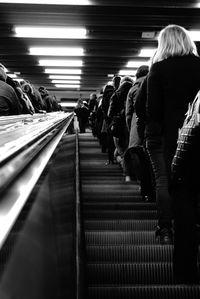 Low angle view of people on escalator at subway station
