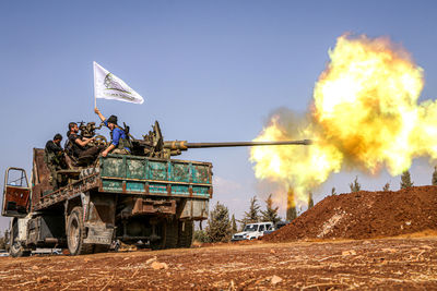 Soldiers firing with weapon from truck