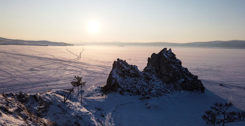 Scenic view of frozen lake against sky during sunset