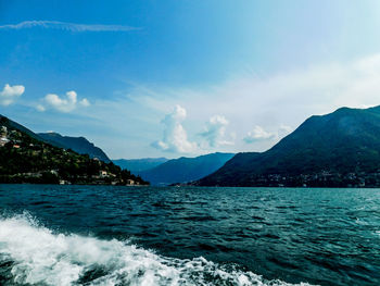 Scenic view of sea and mountains against sky
