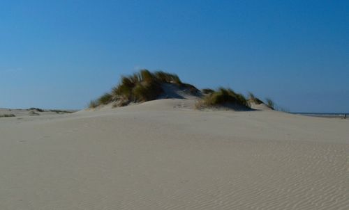 Scenic view of desert against clear blue sky