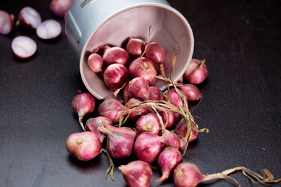 Red onions on black bowl