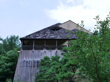 Low angle view of house and trees against sky