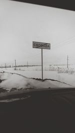 Road sign on snow covered land