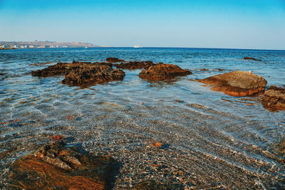 Rocks on beach against clear sky