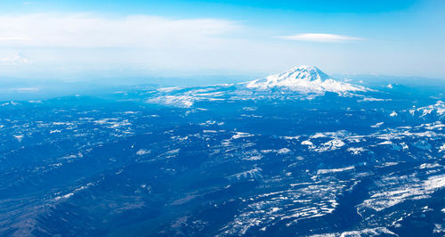 Aerial view of snowcapped mountains and sea against sky