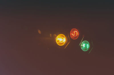 Low angle view of illuminated road signal at night