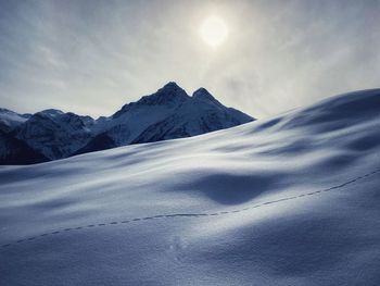 Scenic view of snow covered mountains against sky