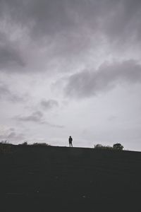 Silhouette man standing on landscape against sky