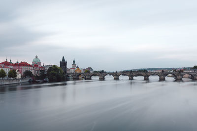 Bridge over river in city against sky