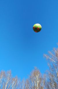 Low angle view of hot air balloon against clear blue sky