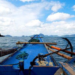 Fishing boat moored on sea against sky