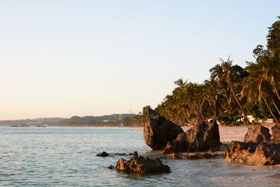 Scenic view of rocks in sea against clear sky