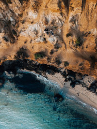 Aerial view of people on cliff by sea