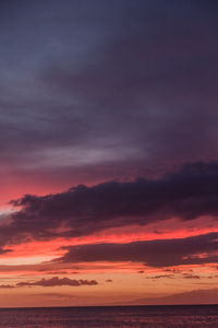 Scenic view of sea against dramatic sky during sunset