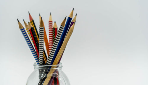 Close-up of multi colored pencils against white background