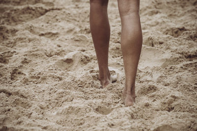Low section of person walking on sand