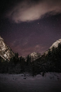 Scenic view of snowcapped mountains against sky at night