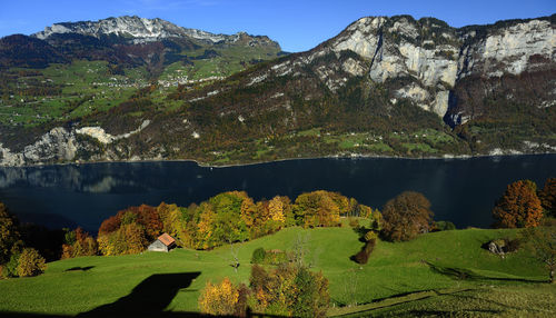 Scenic view of lake and mountains against blue sky