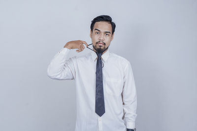 Young man standing against white background