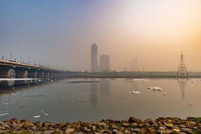 Bridge over river against sky during sunset