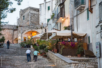 People on street amidst buildings in city